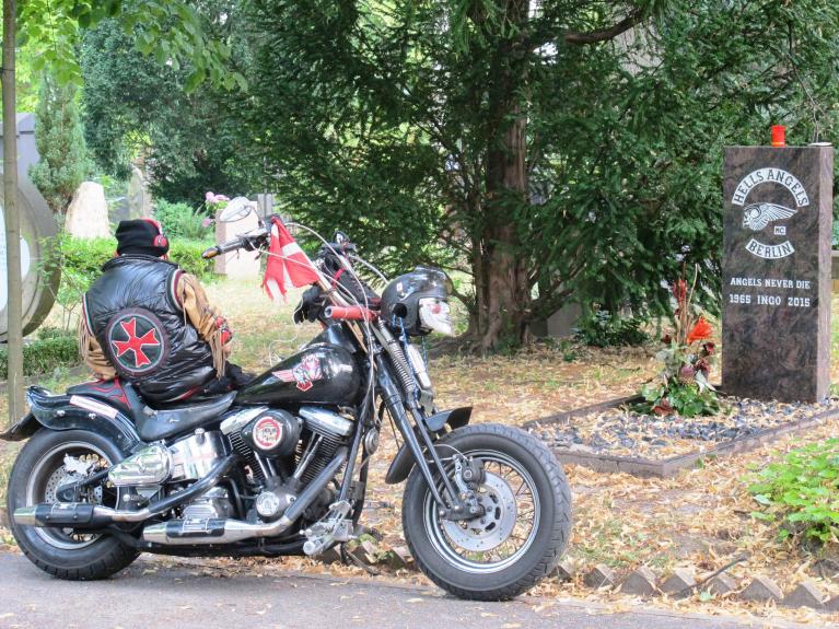 Un hells angel in visita, con tanto di moto, al sepolcro di un amico.