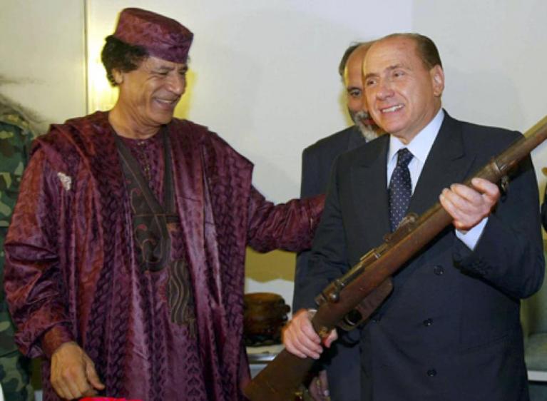 28 ottobre 2002. Il leader libico Muammar Gheddafi regala a Berlusconi l’ultimo fucile italiano rimasto in terra libica, Tripoli (Ansa).