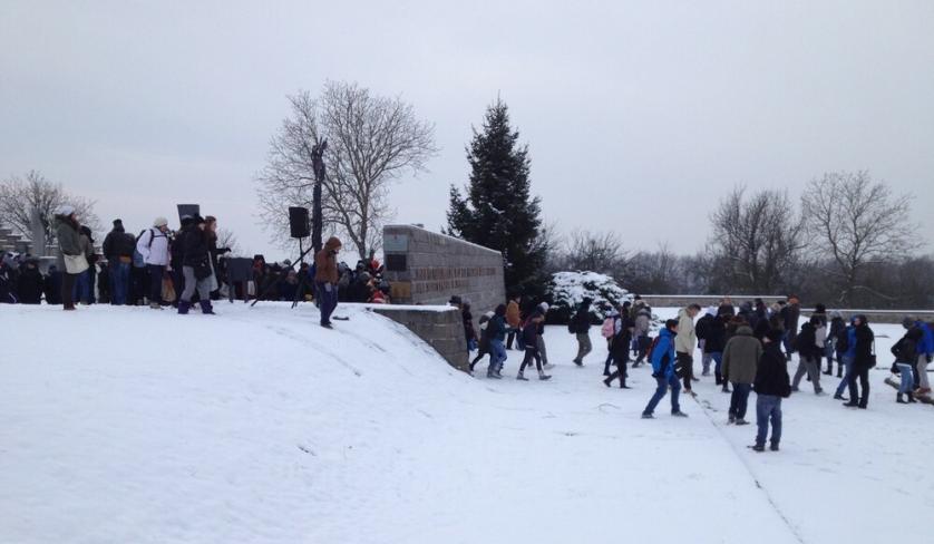 Un gruppo di studenti italiani nella neve, a fianco al monumento italiano