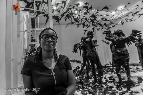 Peju Alatise, behind her is her Flying Girls installation.