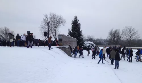 Un gruppo di studenti italiani nella neve, a fianco al monumento italiano