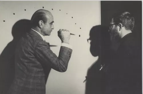 Lucio Fontana mentre realizza Le Jour (1962) presso la casa del collezionista belga Louis Bogaerts. Il pittore Jef Verheyen assiste all’azione filmata da Bogaerts e trasmessa il 3 dicembre 1962 dalla Radio Télévision Belge Francophone. Foto Filip Tas.
