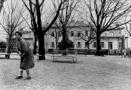 Giovane donna cammina nel cortile dell'ospedale psichiatrico. Copyright Carla Cerati / courtesy Elena Ceratti